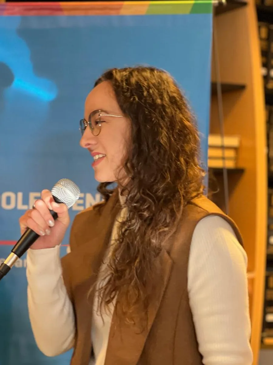 Ab. Diamela Belén Cravero hablando ante el banner de la Secretaría de Niñez, Adolescencia y Familia de la Provincia de Córdoba